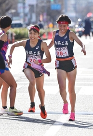 女子・西脇工の１区塩崎彩理（右）からたすきを受け走りだす２区飯塚菜月（撮影・中西幸大）