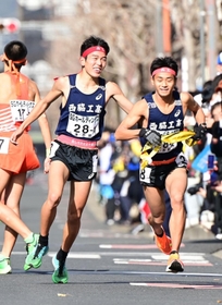 男子１区で区間賞に輝いた西脇工の長嶋幸宝（左）から２区小田伊織へたすきリレー＝京都市内