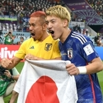 国旗を手に雄たけびをあげる堂安律（右）と長友佑都＝ハリファ国際スタジアム（撮影・金田祐二）