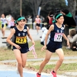 女子・青雲　４区中山志麻（右）からたすきを託された５区久田心愛が笑顔で走り出す＝奈良県橿原市運動公園