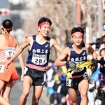 男子１区で区間賞に輝いた西脇工の長嶋幸宝（左）から２区小田伊織へたすきリレー＝京都市内