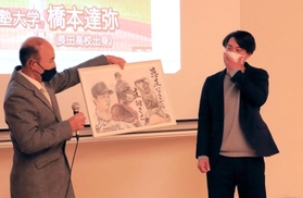 美術の授業を担当していた中学時代の監督から似顔絵入りの絵画を手渡される橋本達弥（右）＝長田高校