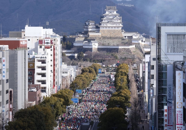 姫路城を背に、一斉にスタートするランナーたち＝２６日午前、姫路市駅前町、ピオレ姫路屋上から