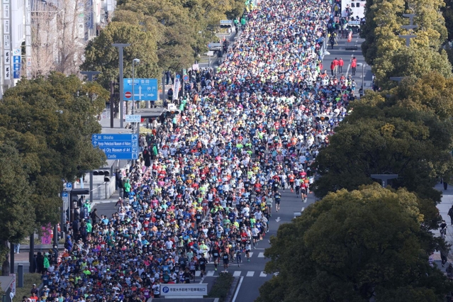 一斉にスタートするランナーたち＝２６日午前、姫路市駅前町、ピオレ姫路屋上から