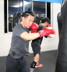 サンドバッグ打ちに励む藤原勇生選手。今夏以降のプロデビューを目指す＝神戸市東灘区、真正ボクシングジム