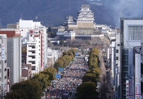 姫路城を背に、一斉にスタートするランナーたち＝２６日午前、姫路市駅前町、ピオレ姫路屋上から