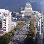 姫路城を背に、一斉にスタートするランナーたち＝２６日午前、姫路市駅前町、ピオレ姫路屋上から