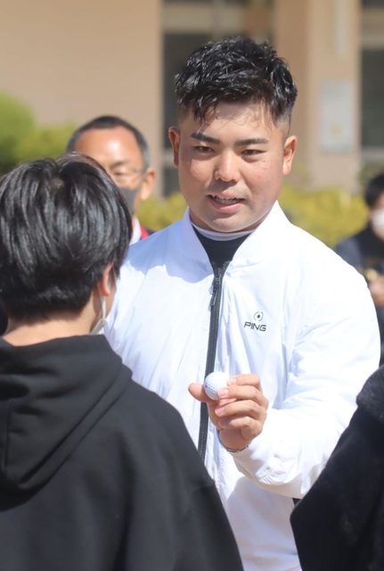 児童にサインボールを手渡す蟬川泰果＝兵庫教育大付属小