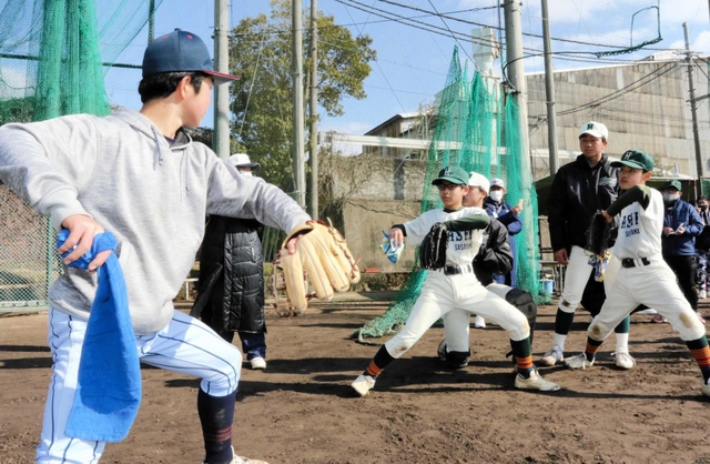 篠山産高での野球教室で高校生（左）からスローイングを教わる中学生ら＝２月４日、丹波篠山市郡家の同校グラウンド