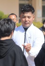 児童にサインボールを手渡す蟬川泰果＝兵庫教育大付属小