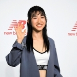 ニューバランスのシューズを手に、笑顔で写真撮影に応じる田中希実＝３日午前、東京都千代田区