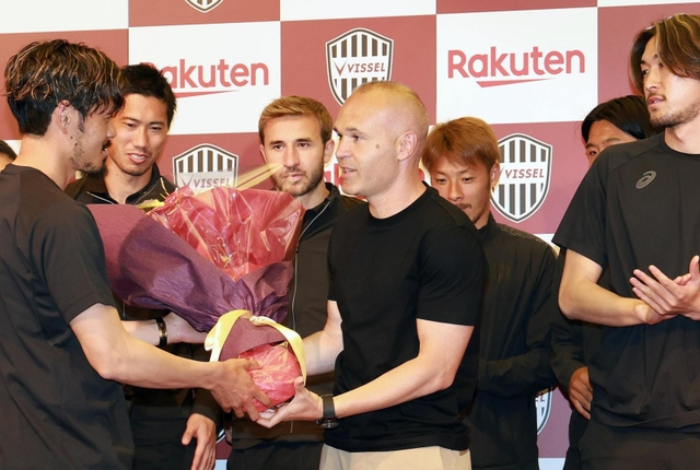 会見後、山口蛍から花束を受け取るイニエスタ（中央）＝２５日午後、神戸市中央区波止場町（撮影・小林良多）