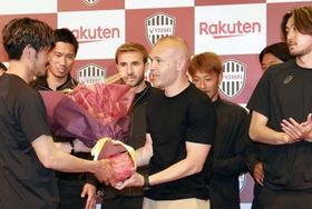 会見後、山口蛍から花束を受け取るイニエスタ（中央）＝２５日午後、神戸市中央区波止場町（撮影・小林良多）