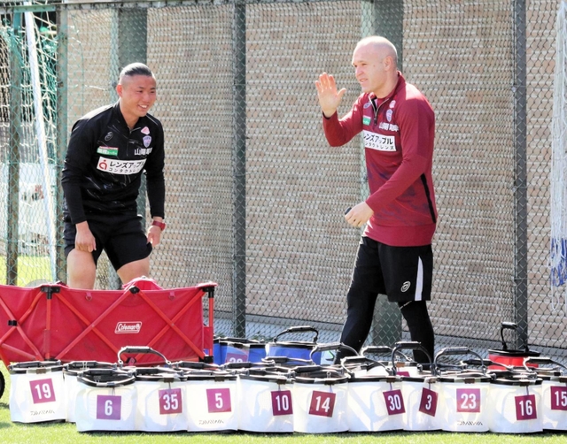 練習場でイニエスタ（右）を出迎える神戸の荒井琢也マネジャー＝３月１４日、神戸市西区のいぶきの森球技場