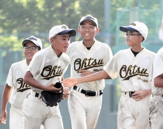 軟式野球決勝・大津-彦根南　初優勝を飾って笑顔で整列に向かう大津ナイン＝紀三井寺公園野球場