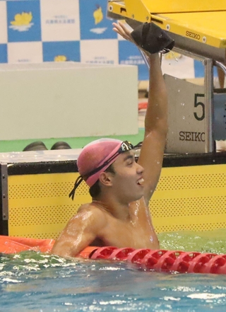 男子１００メートルバタフライ決勝　自己ベストで優勝し、手を振る須磨学園の西川翔己