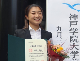 卒業証書を手に笑顔を見せる坂本花織＝神戸市西区、神院大有瀬キャンパス