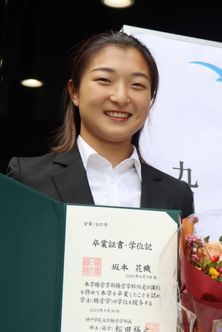 卒業証書を手に笑顔を見せる坂本花織＝神戸市西区、神院大有瀬キャンパス