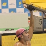 男子１００メートルバタフライ決勝　自己ベストで優勝し、手を振る須磨学園の西川翔己