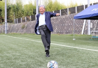 岡崎慎司らが運営する環境配慮型グラウンドを視察した川淵三郎氏。実際にボールを蹴って感触を確かめた＝神戸市西区平野町印路