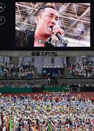 開会式で鹿児島県出身の歌手・長渕剛さんの歌に聴き入る選手ら＝７日午後、鹿児島市与次郎２、白波スタジアム（撮影・斎藤雅志）