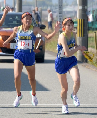 女子・１区区間賞と快走した杉永美空（左）が２区後田乃愛にたすきを渡す（撮影・風斗雅博）