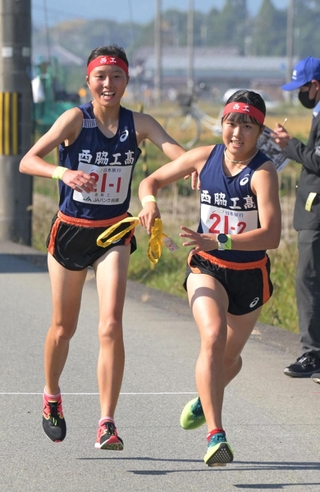 女子・西脇工の１区塩崎彩理（左） からたすきを受け取る２区陰山悠実乃 （撮影・風斗雅博）