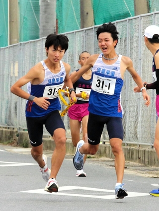 男子・須磨学園の１区堀野正太（右）からたすきを受ける２区三浦彰太（撮影・初鹿野俊）