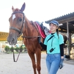 明石乗馬協会の元競走馬理瑠と、担当する清水綾菜さん＝明石市大久保町松陰