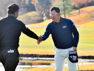 初優勝を決め、プレーオフで争った寺西明（左）と握手を交わす渡部光洋