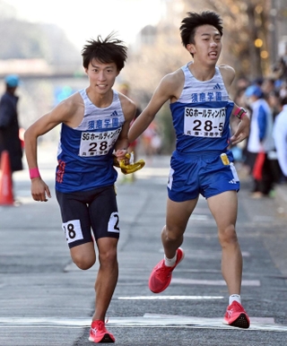 男子・須磨学園の５区梅本陸翔（右）が６区三浦彰太にたすきを託す（撮影・風斗雅博）
