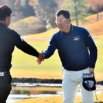 初優勝を決め、プレーオフで争った寺西明（左）と握手を交わす渡部光洋