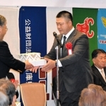 鹿児島国体の競技別成績で天皇杯、皇后杯ともに優勝し、表彰を受ける重量挙げの湊信彦監督（中央）