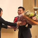 引退セレモニーで板橋美波（左）から花束を受け取る寺内健さん＝尼崎市内のホテル