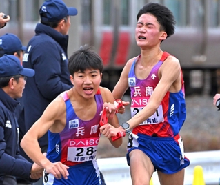 兵庫の１区・折田壮太（右）からたすきを受け取る２区・梅田大陸（撮影・斎藤雅志）