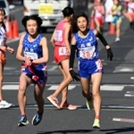 兵庫の２区・田中希実（右）からたすきを受け取り走り出す３区・藤田莉沙＝１４日午後、京都市上京区の第２中継所
