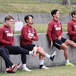座った格好で壁にもたれて片足を上げるトレーニングをする神戸の（左から）扇原、酒井、山口、武藤、大迫＝沖縄県西原町、西原町民陸上競技場（撮影・風斗雅博）