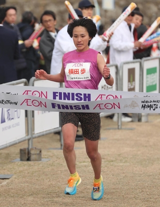 女子で優勝のゴールテープを切る横田歩＝１１日午前、姫路市本町、姫路城三の丸広場（撮影・辰巳直之）