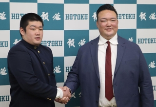 角界入りが決まり、二所ノ関親方（元横綱稀勢の里）と握手する報徳高の今村圭吾（左）＝西宮市の同校
