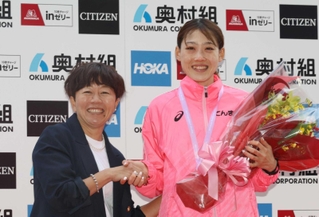 大阪国際女子マラソンで日本記録を更新し、前記録保持者の野口みずきさん（左）から祝福される前田穂南＝１月２８日、ヤンマースタジアム長居