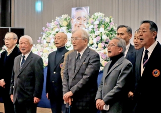 古川さんをしのび、遺影の前で母校である関学大アメフト部の部歌を歌う参列者たち＝大阪市北区、大阪新阪急ホテル