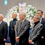 古川さんをしのび、遺影の前で母校である関学大アメフト部の部歌を歌う参列者たち＝大阪市北区、大阪新阪急ホテル