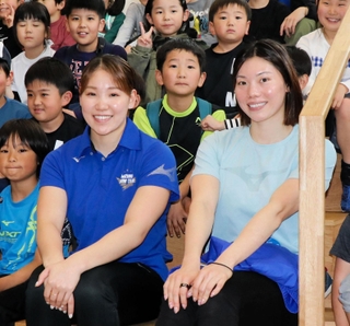 競泳女子で２大会連続五輪代表を決め、イベントで子どもたちと記念写真に納まる白井璃緒（中央左）と青木玲緒樹＝大阪市住之江区南港北１