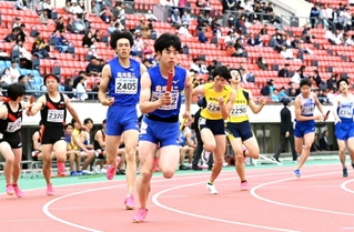 バトンをつなぐ高校男子１６００メートルリレーの選手たち＝２０日午後、ユニバー記念競技場（撮影・大田将之）