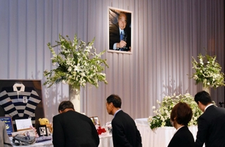 金川好延さんをしのぶ会で、遺影や思い出の品を前に語り合う参列者たち＝神戸ポートピアホテル