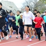 子どもたちとトラックを走る小林祐梨子さん（中央）と斎藤元彦知事＝きしろスタジアム