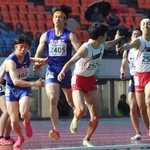 バトンをつなぐ滝川第二と社の選手たち＝ユニバー記念競技場（撮影・笠原次郎）