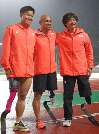 男子走り幅跳び（義足・機能障害Ｔ６３）決勝の競技を終え、笑顔を見せる５位の山本篤（中央）＝１９日夜、神戸市須磨区緑台、ユニバー記念競技場（撮影・笠原次郎）