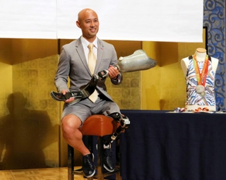 競技用義足を手に写真に収まるパラ陸上界の第一人者、山本篤＝神戸市中央区東川崎町１、ホテルクラウンパレス神戸