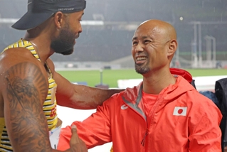 世界パラ陸上で金メダルを獲得したドイツの選手（左）と健闘をたたえ合う山本篤さん＝１９日、ユニバー記念競技場